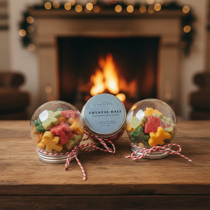 Decorative crystal balls with candy stars on a wooden surface in front of a fireplace.