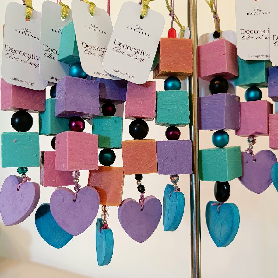 Decorative olive oil soap with colorful cubes and heart shaped scented plaster on a stand, branded 'CalliopeShop'.