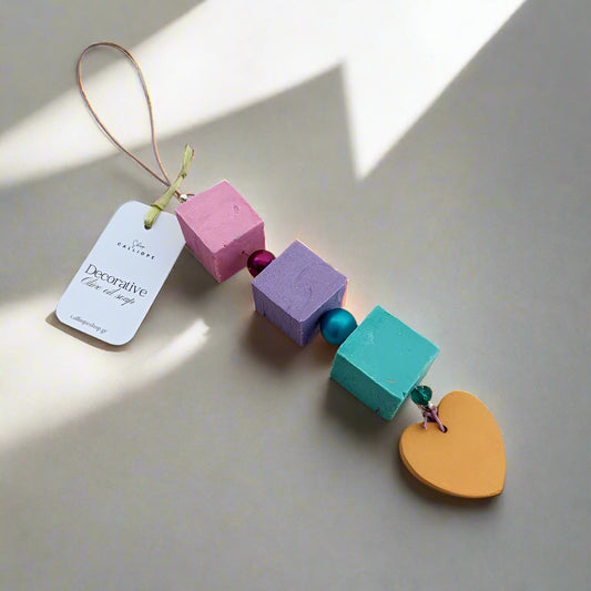 Colorful decorative charm with wooden blocks and a heart shape on a beige background