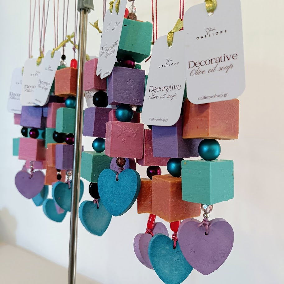 Decorative olive oil soap cubes with heart shapes hanging on a stand.