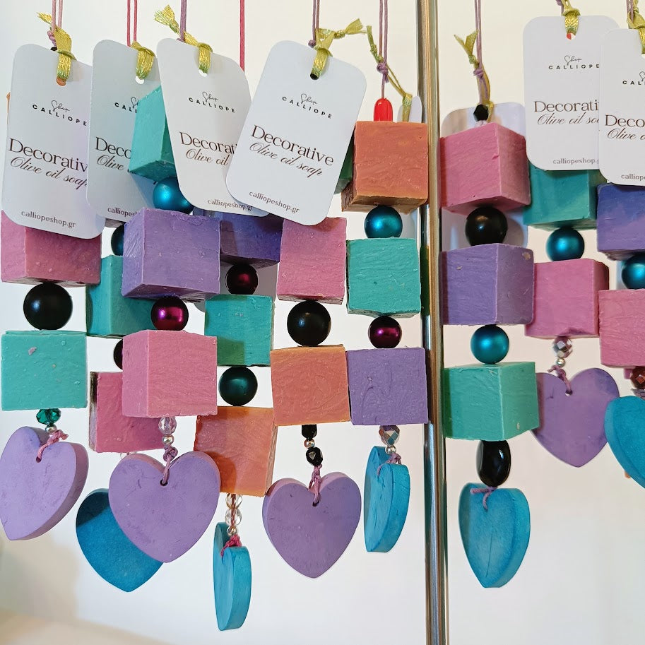 Colorful decorative soap bars with heart and cube shapes on a stand.