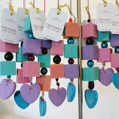Colorful decorative soap bars with heart and cube shapes on a stand.