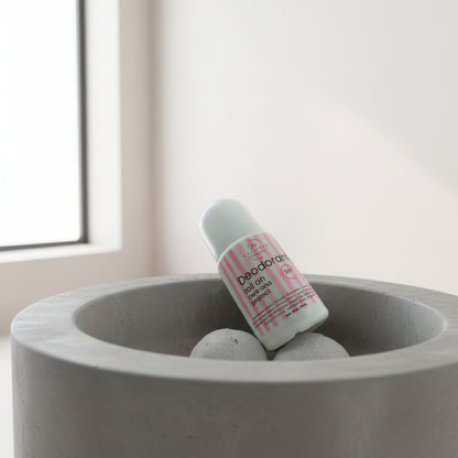 Deodorant bottle in a concrete planter with a light background
