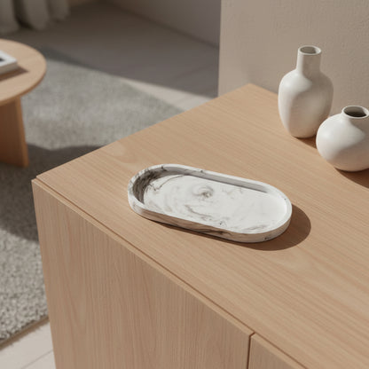 Marble tray on a wooden surface with two vases in the background