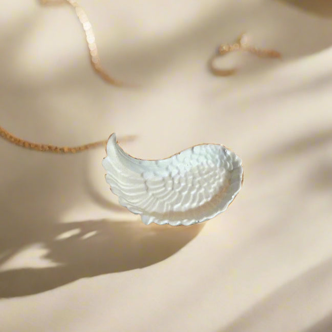 Ένα λευκό φτερό δισκος τοποθετημένος σε μπέζ επιφάνεια με σκίαση