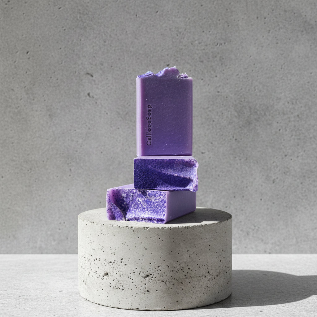 Three purple soap bars stacked on a concrete stand