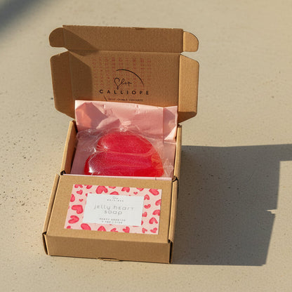 Open cardboard box with a red jelly soapon a white surface