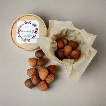 Chestnuts in a paper craft box and on a white surface with a label on a white background