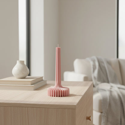 Pink textured candle on a white background