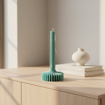Teal candle holder with textured base on a beige surface