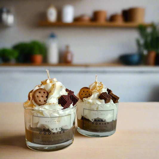 Two glass jars of dessert look candle with whipped cream and cookies on a wooden surface.