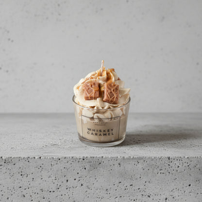 Κοντινό πλάνο gourmet κεριού σόγιας Whiskey Caramel με λεπτομέρειες από σαντιγί κεριού και κύβους καραμέλας