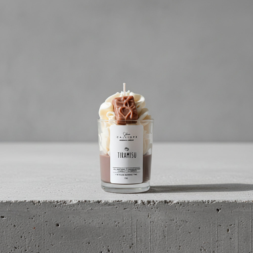 Tiramisu-themed candle in a glass jar on a surface with a dark background
