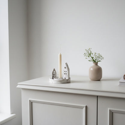 Candle holder on a white cabinet against a plain wall