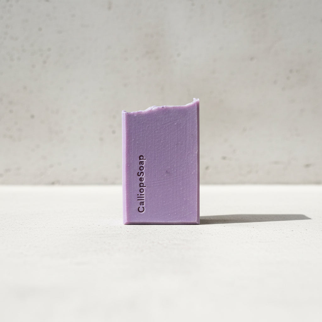 Purple bar of soap with 'Calliope Soap' branding on a grey surface.