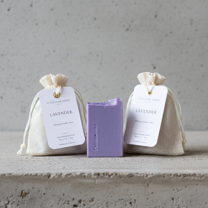 Two lavender-scented soap bags with a bar of soap on a light surface.