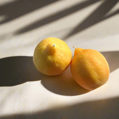 Two yellow earrings on a light background with shadow patterns.