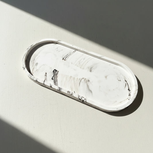 Marble-patterned oval tray on a light gray background
