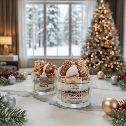 Two Melomakarono candles on a table with Christmas decorations and a tree in the background.