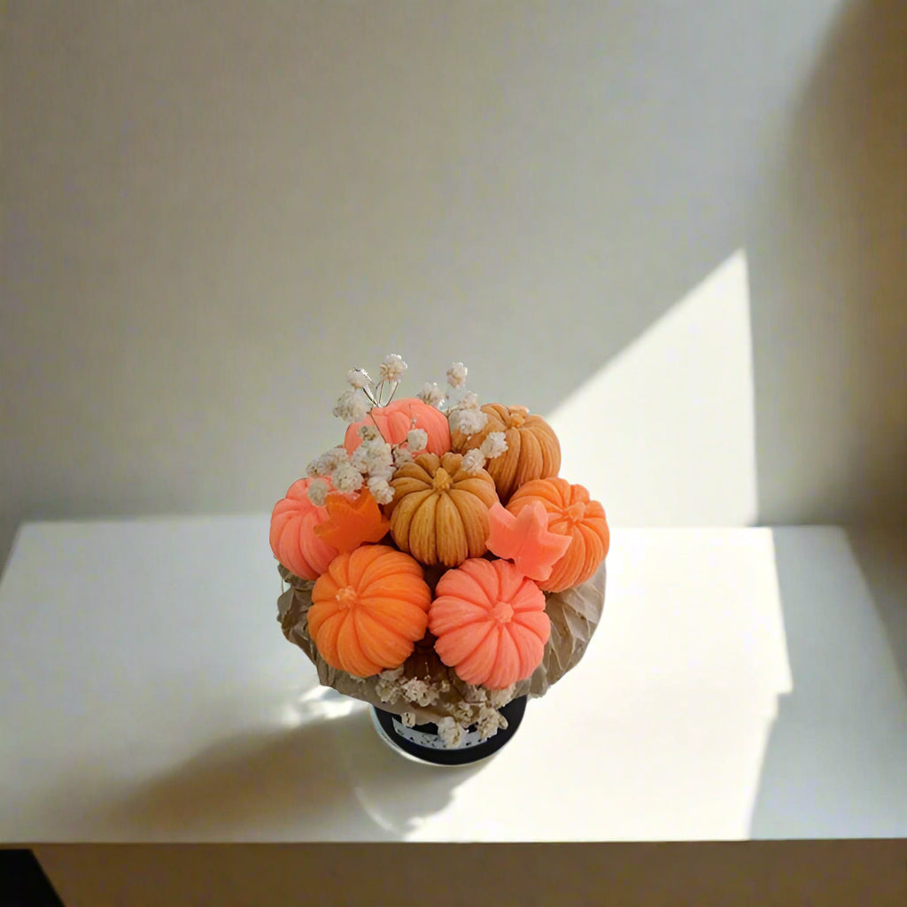 Decorative arrangement of orange and beige pumpkins on a white surface
