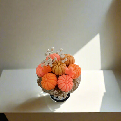 Decorative arrangement of orange and beige pumpkins on a white surface