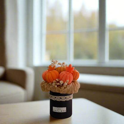 Decorative arrangement of pumpkins in a vase on a table with a blurred background