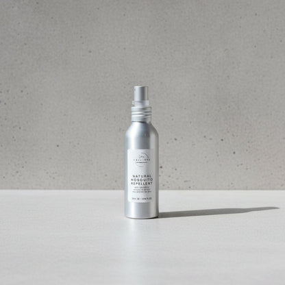 Silver spray bottle labeled 'Natural Insect Repellent' on a wooden surface.