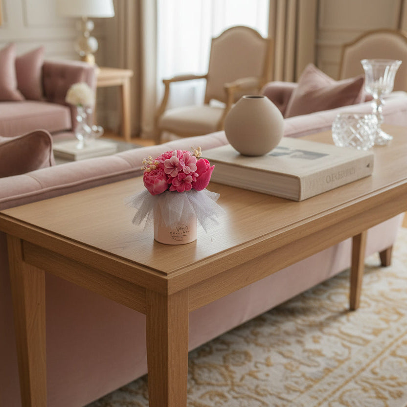 Living room with pink sofa, wooden coffee table, and decorative items.