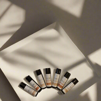 Containers of 'Vanilla & Praline' lip balm with matte black and white labels, positioned on a light background.