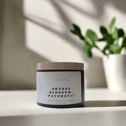 Candle jar with wooden lid and label on a white surface