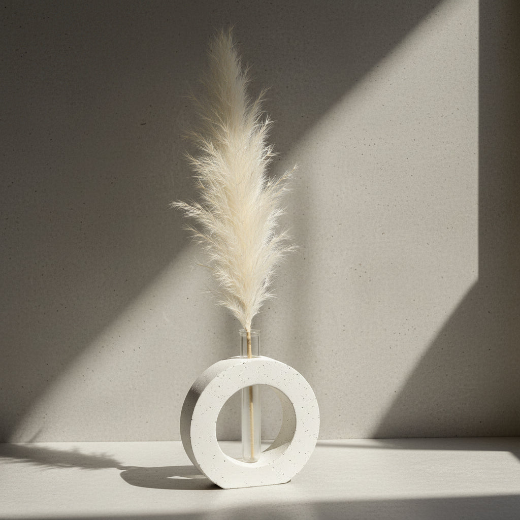 A handcrafted decorative vase made of cement in an OVAL shape with an integrated glass tube, displayed with a plant inside it.