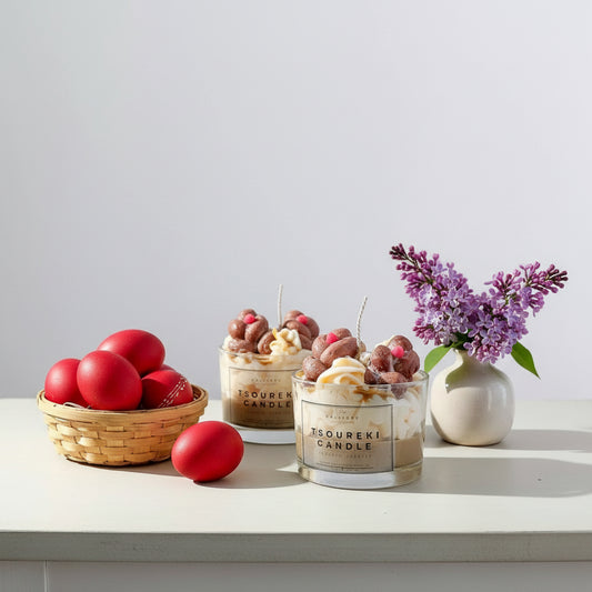 Two tsoureki glass candles with decorative elements on a white surface