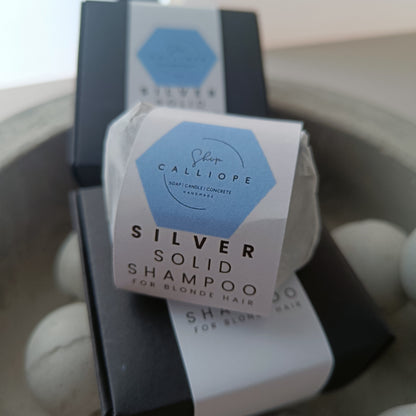 A  solid shampoo bar packaged and labeled as silver solid shampoo for blonde hair