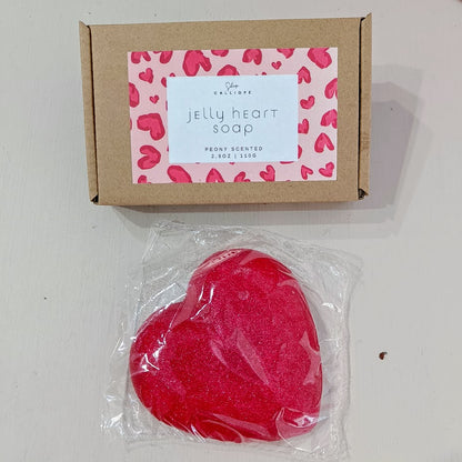 Red heart-shaped jelly soap in clear packaging with a cardboard box featuring a heart pattern.