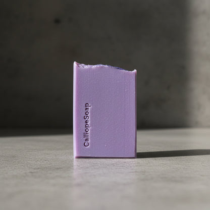 A bar of purple soap with CalilopeSoap branding on a grey surface.