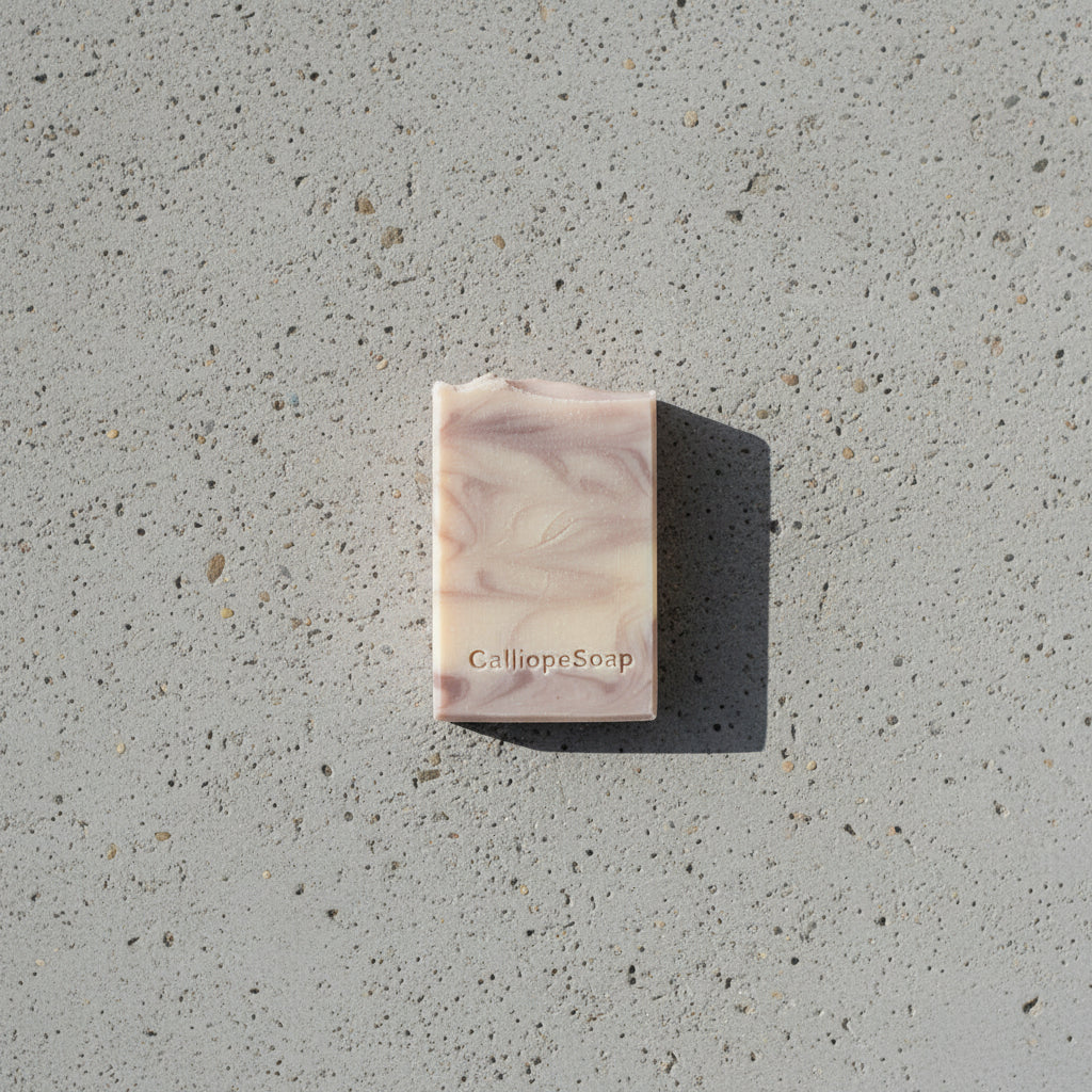 Bar of soap with 'CalliopeSoap' branding on a concrete surface.