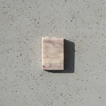 Bar of soap with 'CalliopeSoap' branding on a concrete surface.