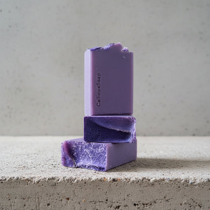 Purple soap bars on a concrete surface with a blurred background