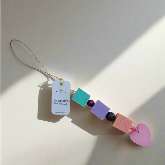 Decorative soap with colorful beads and a heart shape on a light gray background