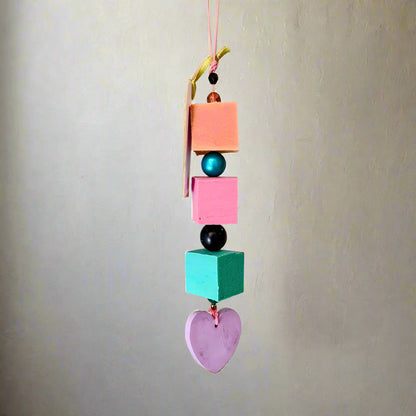 Colorful hanging decorative item with geometric shapes and beads on a plain background