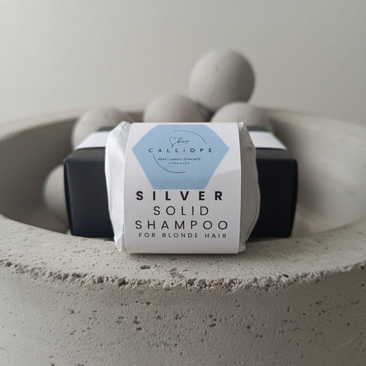 A  solid shampoo bar packaged and labeled as silver solid shampoo for blonde hair