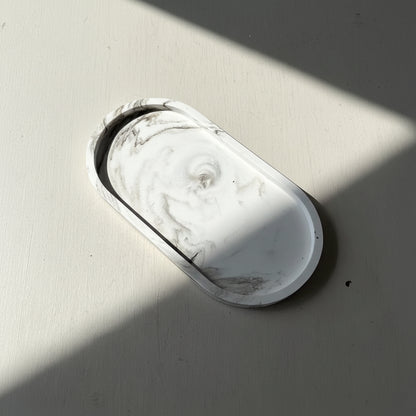 Marble-patterned oval object on a gray surface