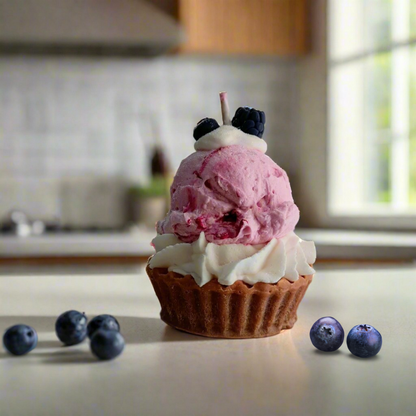 Cupcake with pink ice cream and blueberries on a kitchen counter