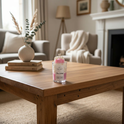 Pink candle with decorative elements on a white surface