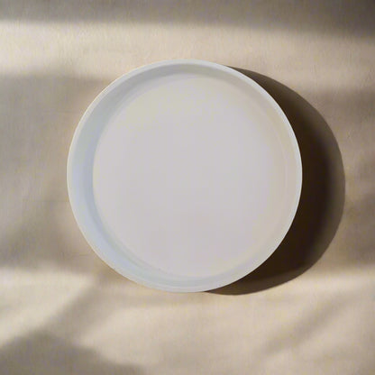 A decorative round porcelain dish with a minimalistic geometric pattern in blue and white colors.