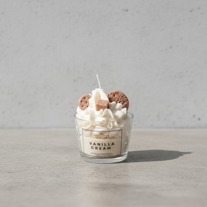 Αρωματικό κερί Vanilla Cream της Calliope σε γυάλινο ποτήρι, με φόντο ακατέργαστο τσιμέντο.