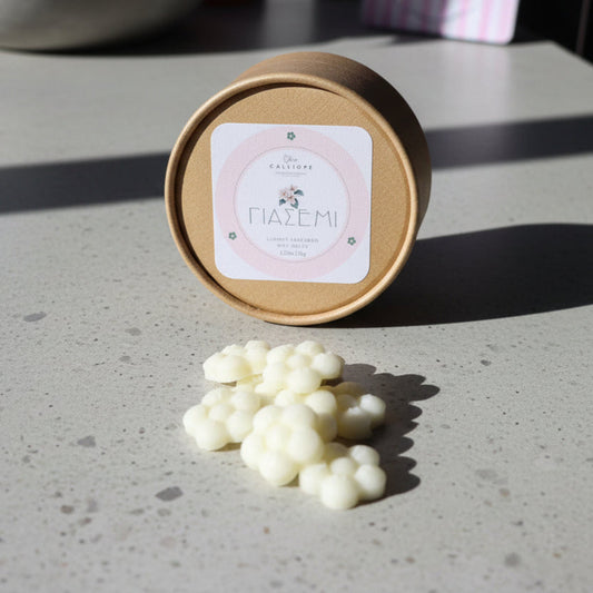 Χειροποίητα wax melts γιασεμί σε σχήμα λευκών λουλουδιών μπροστά στη χάρτινη οικολογική συσκευασία Calliope.
