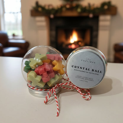 Decorative crystal ball with gingerbread-themed candies and a labeled container on a surface with a fireplace in the background.