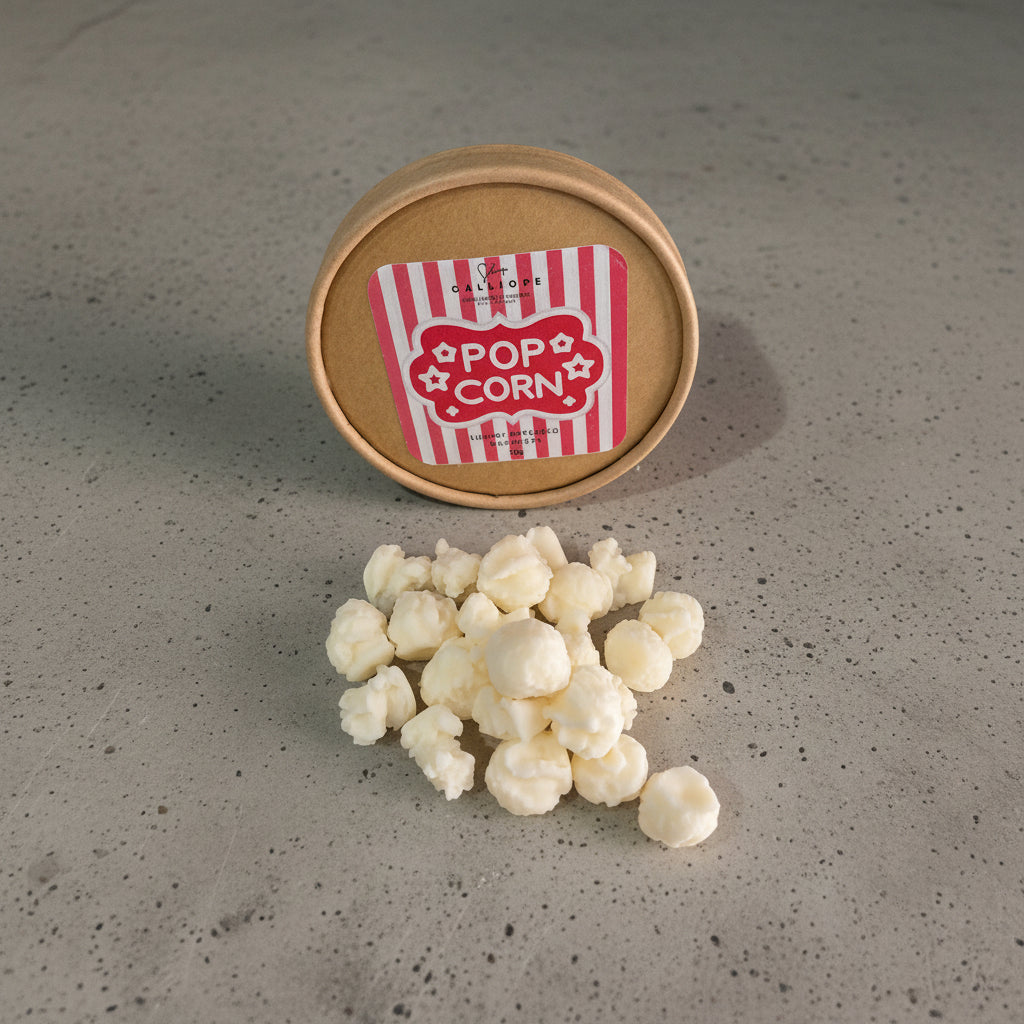 wax melts σε σχήμα ποπ κορν σε κραφτ κουτί πάνω σε τσιμεντένια επιφάνεια