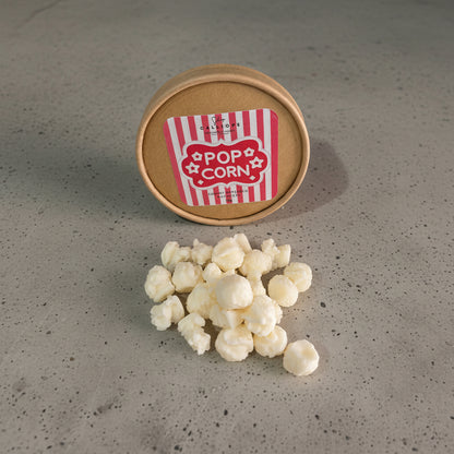 wax melts σε σχήμα ποπ κορν σε κραφτ κουτί πάνω σε τσιμεντένια επιφάνεια